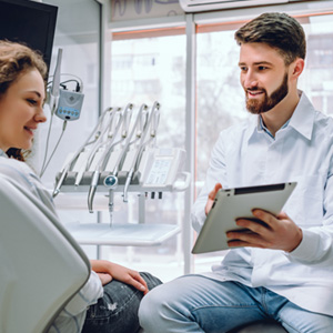 Dentist and patient reviewing information on tablet